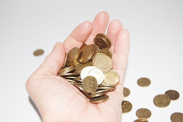 Close-up view of a pile of coins inside a person’s palm.
