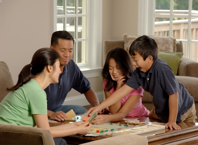 A family plays a board game indoors.