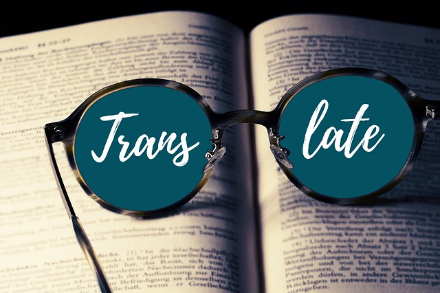 A pair of glasses with the word “Translate” in their lens lies atop a book.
