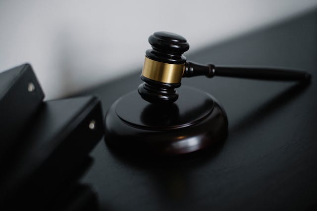 A black wooden gavel on a black table.
