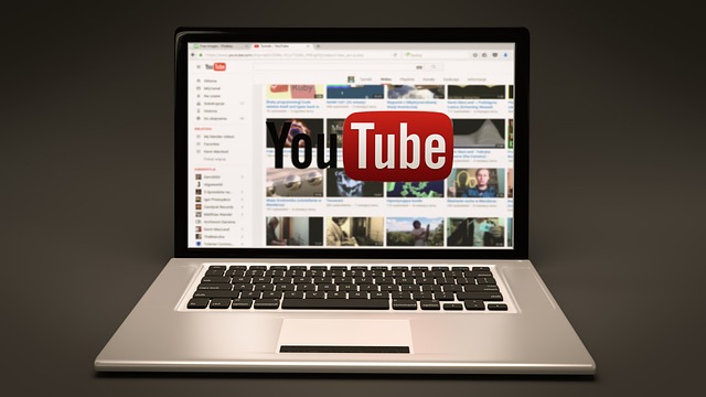 The YouTube homepage on a silver laptop screen.
