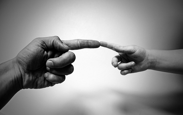 An adult and a child link index their fingers.