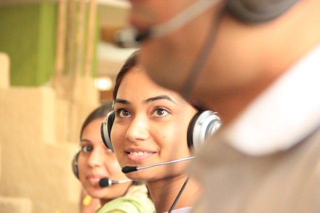 A group of customer service agents with headphones.
