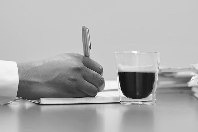 Someone signs a document on a desk.
