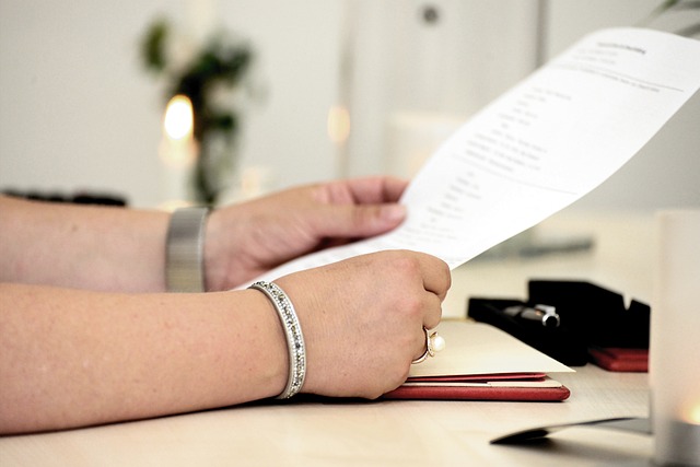 A person looks through a document in their hand.
