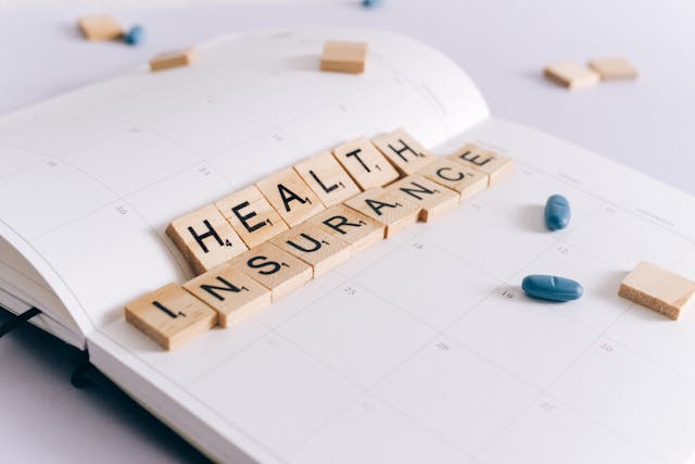 Scrabble tiles form “Health Insurance.”