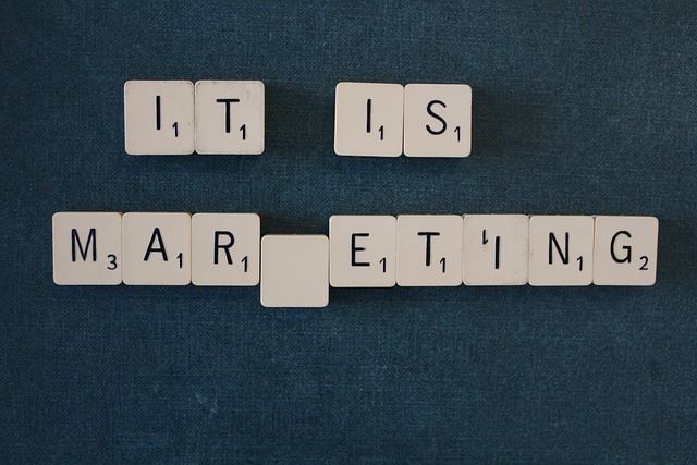 An arrangement of Scrabble tiles in the process of spelling “It is marketing.”
