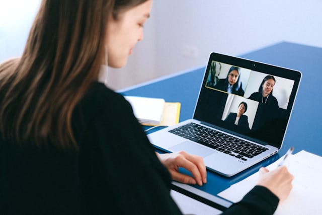 A person writes notes from a live video call.