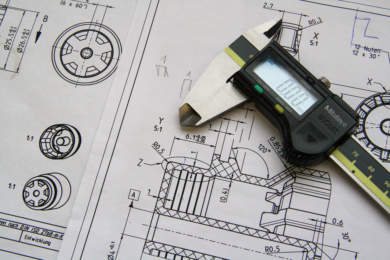 Close-up view of a caliper and technical drawings on a document.