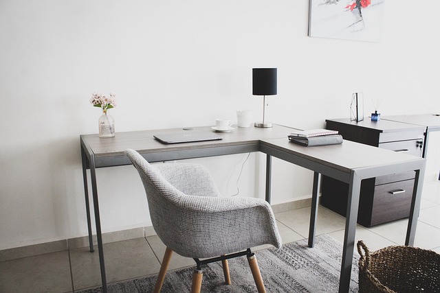 A home office setup with furniture, writing materials, and a laptop.
