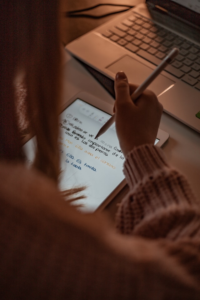 一个女孩在用 iPad 翻译西班牙语。 